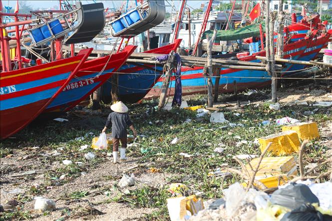 Việc tiếp cận các tàu, thuyền đang neo đậu gặp nhiều khó khăn do rác thải bủa vây dày đặc. Ảnh: Xuân Tiến - TTXVN 