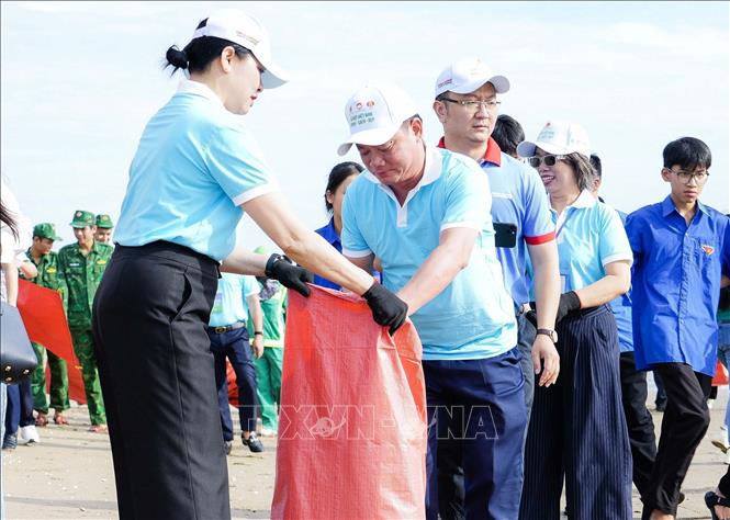 Bí thư tỉnh ủy Nghệ An Nguyễn Khắc Thận tham gia làm sạch bãi biển Cửa Lò. Ảnh: Trịnh Duy Hưng - TTXVN 