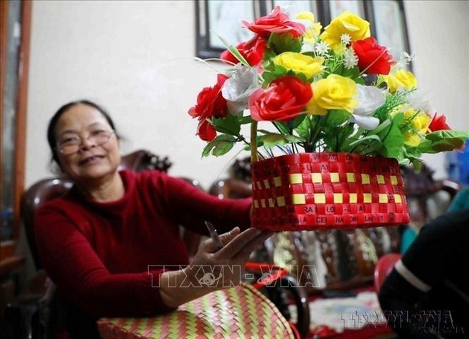 Phụ nữ cao tuổi phường Hà Trung, thành phố Hạ Long (cũ), tỉnh Quảng Ninh thu gom về biến những chiếc dây buộc vật liệu xây dựng thành chiếc làn đi chợ, sọt đựng rác hay giỏ cắm hoa, ống bút… góp phần bảo vệ môi trường, giảm thiểu lượng túi nilon. Ảnh: Thanh Tùng - TTXVN