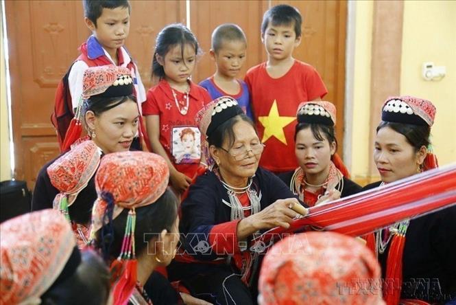 Phụ nữ cao tuổi Câu lạc bộ Dao Thanh y thôn Éo, xã Phúc Ninh, huyện Yên Sơn (cũ), tỉnh Tuyên Quang truyền nghề dệt thổ cẩm đồng bào Dao cho thế hệ trẻ. Ảnh: Nam Sương – TTXVN