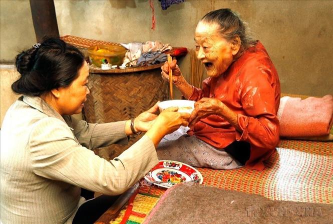Cộng tác viên dân số hỗ trợ chăm sóc người cao tuổi có hoàn cảnh đặc biệt khó khăn tại huyện Hòa Vang (Đà Nẵng). Ảnh: Dương Ngọc – TTXVN
