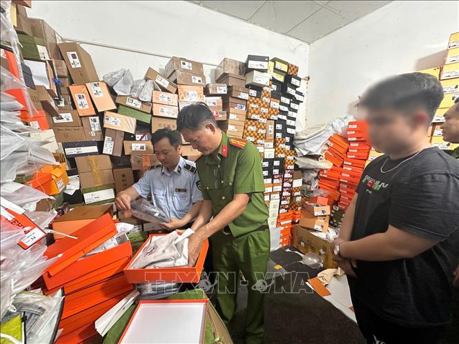 Công an thành phố Cần Thơ phối hợp Chi Cục quản lý thị trường thành phố kiểm đếm số quần áo “giả” thương hiệu nổi tiếng tại cửa hàng T.H Luxury. Ảnh: TTXVN phát

