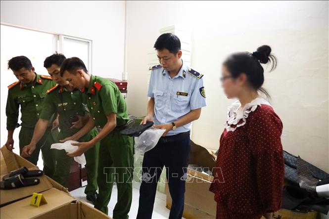 Công an thành phố Cần Thơ phối hợp Chi Cục quản lý thị trường TP Cần Thơ kiểm đếm, niêm phong số lượng lớn dép “giả” thương hiệu nổi tiếng tại cửa hàng T.D Luxury. Ảnh: TTXVN phát

