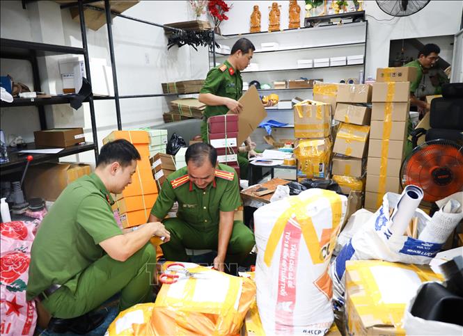 Công an thành phố Cần Thơ phối hợp Chi Cục quản lý thị trường TP Cần Thơ kiểm đếm, niêm phong số lượng lớn dép “giả” thương hiệu nổi tiếng tại cửa hàng T.D Luxury. Ảnh: TTXVN phát

