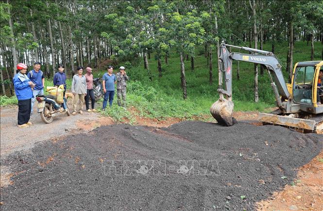 Người dân thôn Sơn Phú, xã Thọ Sơn góp tiền để đổ đá dăm, thêu máy xúc san gạt mặt bằng. Ảnh: Đậu Tất Thành – TTXVN.