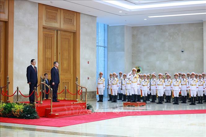 Thủ tướng Lê Minh Hưng và Thủ tướng Lào Sonexay Siphandone nghe Quân nhạc cử Quốc thiều hai nước. Ảnh: Dương Giang – TTXVN