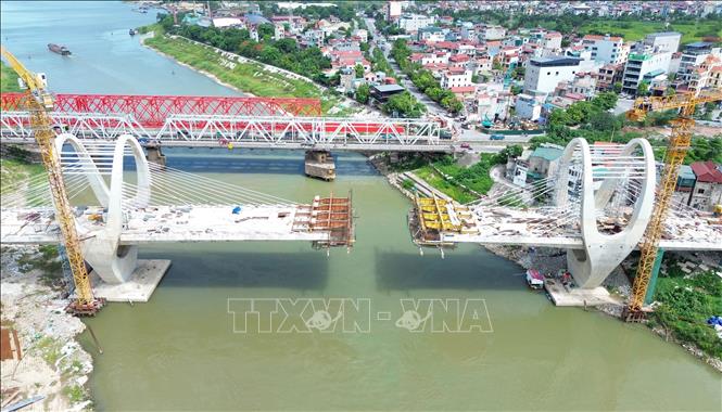 Nhà thầu hiện đang đẩy nhanh tiến độ thi công các đốt dầm theo phương pháp đúc hẫng cân bằng, từng bước vươn ra giữa sông để chuẩn bị hợp long nhịp chính. Ảnh: Quốc Khánh - TTXVN
