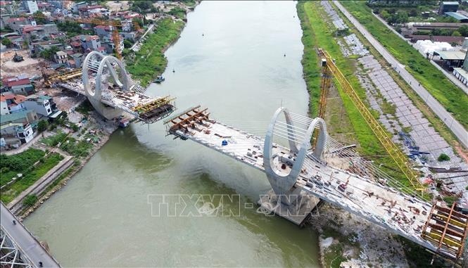 Cầu đường bộ dài 382m, kết hợp dây văng, rộng 18,5m, tĩnh không dưới cầu 4,75m; đường dẫn dài 318m, vận tốc thiết kế 80km/h, gồm 6 làn xe cơ giới, 2 làn xe hỗn hợp, giai đoạn phân kỳ trước mắt quy mô 4 làn xe cơ giới. Ảnh: Quốc Khánh - TTXVN