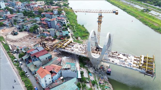 Đường dẫn lên cầu đường bộ phía đường Hà Huy Tập với đường Phan Đăng Lưu (xã Phù Đổng) đang được nhà thầu đẩy nhanh tiến độ thi công sau khoảng thời gian dài vướng mặt bằng. Ảnh: Quốc Khánh - TTXVN