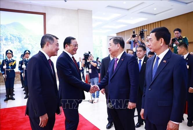 Thủ tướng Lê Minh Hưng giới thiệu với Thủ tướng Lào Sonexay Siphandone thành viên đoàn Việt Nam tham dự lễ đón. Ảnh: Dương Giang – TTXVN