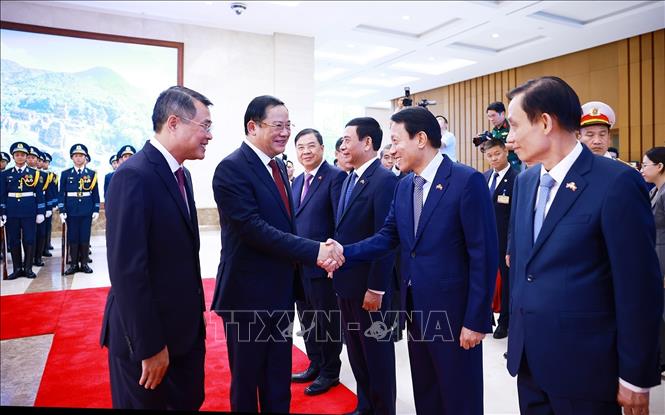 Thủ tướng Lê Minh Hưng giới thiệu với Thủ tướng Lào Sonexay Siphandone thành viên đoàn Việt Nam tham dự lễ đón. Ảnh: Dương Giang – TTXVN