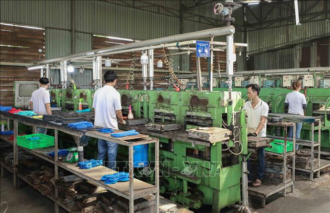 Công nhân vận hành hệ thống đúc gót giày. Ảnh: Phan Phương – TTXVN