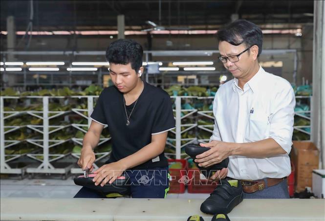 Anh Nguyuyễn Văn Nam, Giám đốc Kỹ thuật Công ty TNHH Nam Bình giám sát chặt quy trình sản xuất giày với thương hiệu Prowin, đảm bảo chất lượng tốt nhất khi đến tay người tiêu dùng. Ảnh: Phan Phương – TTXVN