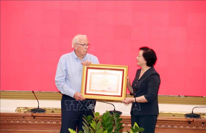 Phó Thủ tướng Phạm Thị Thanh Trà trao Bằng khen của Thủy tướng Chính phủ cho ông Robert Ambrose Connor, cựu chiến binh Hoa Kỳ, đại diện Nhóm tình nguyện thu thập thông tin và tư liệu hỗ trợ Việt Nam tìm kiếm liệt sĩ. Ảnh: Xuân Khu - TTXVN