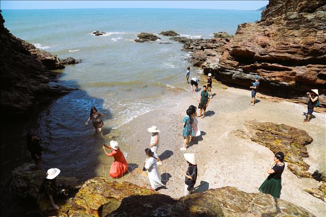 Đông đảo du khách đang trải nghiệm, tham quan, chụp ảnh tại vịnh nhỏ nằm trong lòng hang Mũi Trâu. Ảnh: Xuân Tiến - TTXVN 