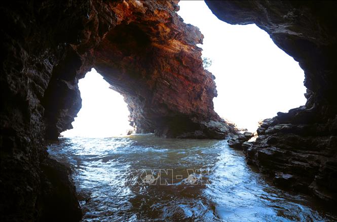 Hang Mũi Trâu là mũi đá nhô ra biển, được hình thành qua hàng triệu năm phong hóa, bào mòn của sóng biển đã tạo thành hai lỗ khoét sâu trong núi đá trông giống như mũi trâu. Ảnh: Xuân Tiến - TTXVN 