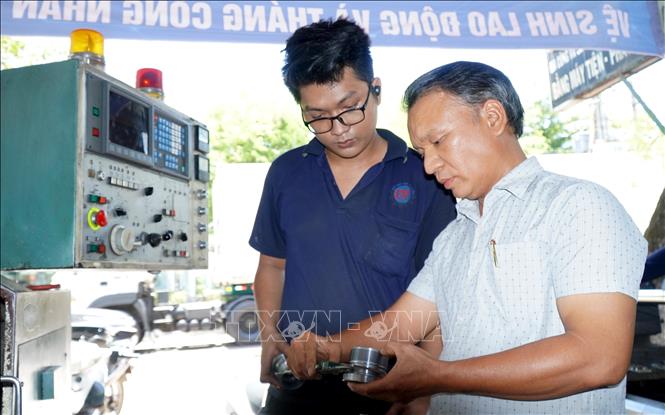 Ông Lê Tấn Thêm (áo trắng), Giám đốc Công ty TNHH sản xuất Thương mại và Dịch vụ tàu thuyền Lê Thêm (TP. Quy Nhơn, tỉnh Bình Định) được ngư dân cả nước ưu ái đặt cho cái tên “kỹ sư chân đất” hay “bà đỡ” với những phát minh, sáng tạo công nghệ góp phần hiện đại hóa đội tàu đánh bắt xa bờ, hướng tới phát triển nghề cá bền vững. Ảnh: Lê Phước Ngọc - TTXVN