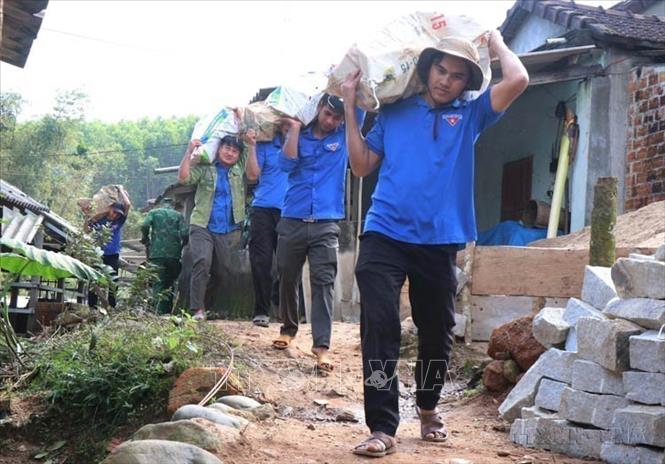 Lực lượng đoàn thanh niên hỗ trợ vận chuyển gạch, đá xây nhà cho người dân khu vực có địa hình dốc tại Chương trình Xóa nhà tạm “đồng lòng vì người khó-gắn kết cộng đồng” của tỉnh Quảng Ngãi. Ảnh: Phạm Cường - TTXVN
