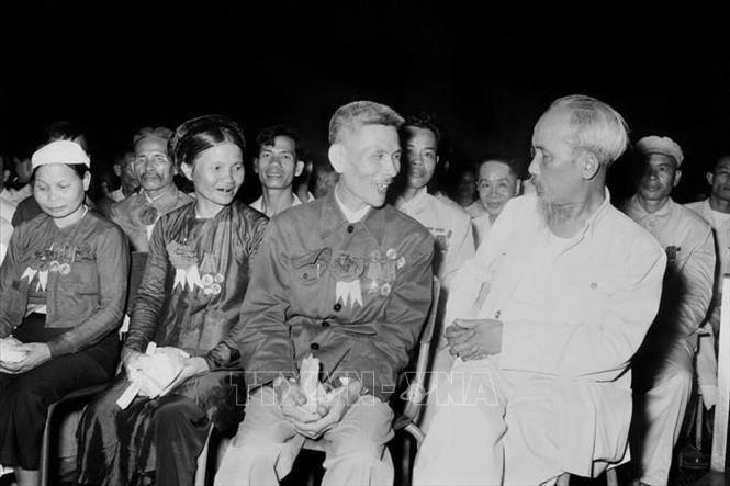 Chủ tịch Hồ Chí Minh trò chuyện thân mật với Anh hùng Lao động Nguyễn Phúc Đồng (ngành Quân giới) và nữ anh hùng Nguyễn Thị Năm (dệt Nam Định) trong buổi họp mặt các đại biểu dự Đại hội liên hoan Anh hùng, Chiến sĩ thi đua công-nông-binh toàn quốc lần thứ II (7/7/1958). Ảnh: Tư liệu TTXVN
