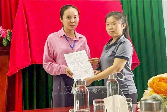 Bà Trần Thị Thu Hồ (bên trái) nhận Quyết định công nhận đảng viên chính thức ngày 3/6/2026, sau hơn 5 năm Quyết định được ký ban hành. Ảnh: TTXVN phát