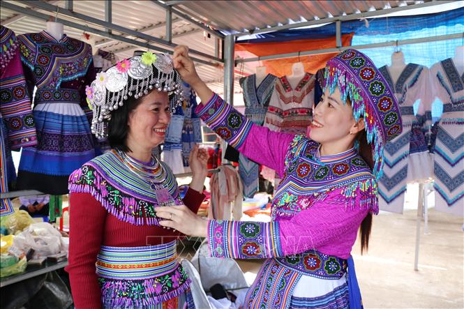 Du khách trải nghiệm mặc trang phục truyền thống của đồng bào Mông tại chợ phiên Đắk R’măng (xã Tà Đùng, tỉnh Lâm Đồng). Ảnh: Nguyễn Huy Thành – TTXVN