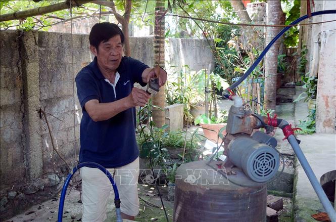 Nhiều hộ dân xã Tân Gianh (Quảng Trị) sử dụng máy để bơm nước nhiễm phèn phục vụ cho việc sinh hoạt vào mùa hè. Ảnh: Tá Chuyên - TTXVN 