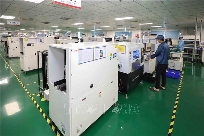 Các kỹ sư đang vận hành, giám sát máy tự động trên dây chuyền công nghệ dán bề mặt. Ảnh: Phan Phương - TTXVN