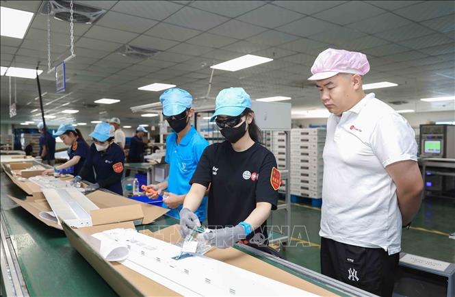 Ông Zhang Hao Zhe - Quản lý chất lượng đang trực tiếp giám sát quy trình lắp ráp linh kiện điện tử, đảm bảo kiểm soát nghiêm ngặt chất lượng sản phẩm trước khi xuất xưởng theo tiêu chuẩn quốc tế. Ảnh: Phan Phương - TTXVN