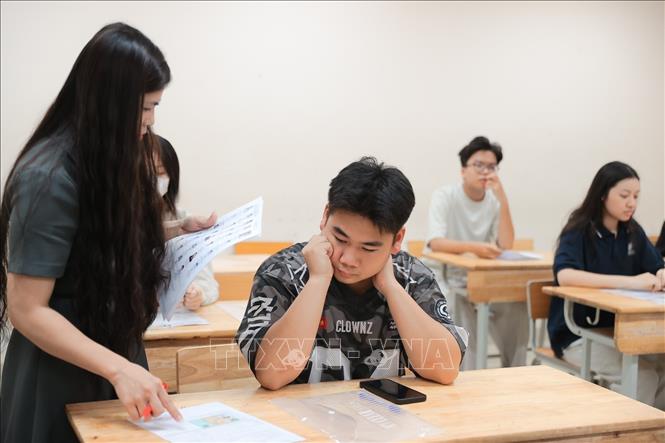 Giám thị kiểm tra thông tin thí sinh. Ảnh: Minh Quyết - TTXVN