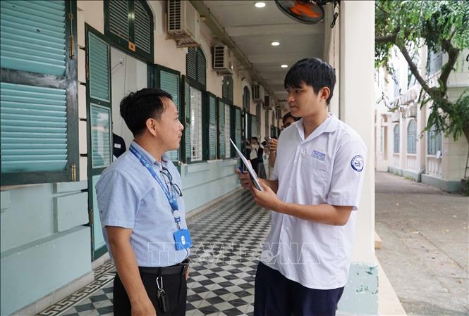 Cán bộ tại điểm thi Trường THPT Lê Quý Đôn hướng dẫn thí sinh đến phòng thi. Ảnh: Thu Hoài - TTXVN
