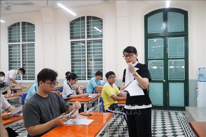 Cán bộ coi thi tại điểm thi Trường THPT Lê Quý Đôn trao đổi với thí sinh về những vấn đề cần lưu ý khi làm bài thi. Ảnh: Thu Hoài - TTXVN