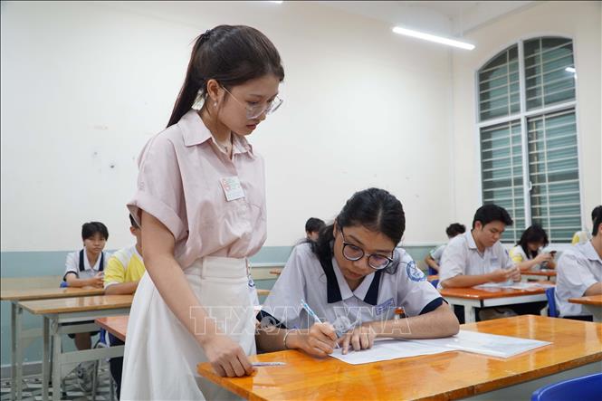 Cán bộ coi thi hướng dẫn thí sinh kiểm tra thông tin. Ảnh: Thu Hoài - TTXVN