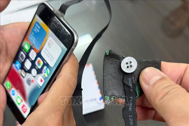 Thiết bị được thí sinh giấu trong người gồm camera ngụy trang kết nối điện thoại, tai nghe siêu nhỏ gắn tai. Ảnh: TTXVN phát