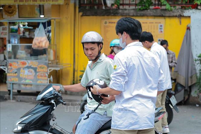 Đưa con đến điểm thi, phụ huynh nhắc nhở con kiểm tra lại đồ dùng trước khi bước vào phòng thi. Ảnh: Phạm Tuấn Anh - TTXVN
