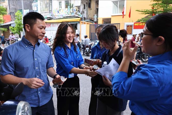Lực lượng thanh niên tình nguyện phát nước uống miễn phí cho thí sinh tại điểm thi Trường THCS Ngô Sĩ Liên, phường Cửa Nam (Hà Nội). Ảnh: Minh Đức - TTXVN