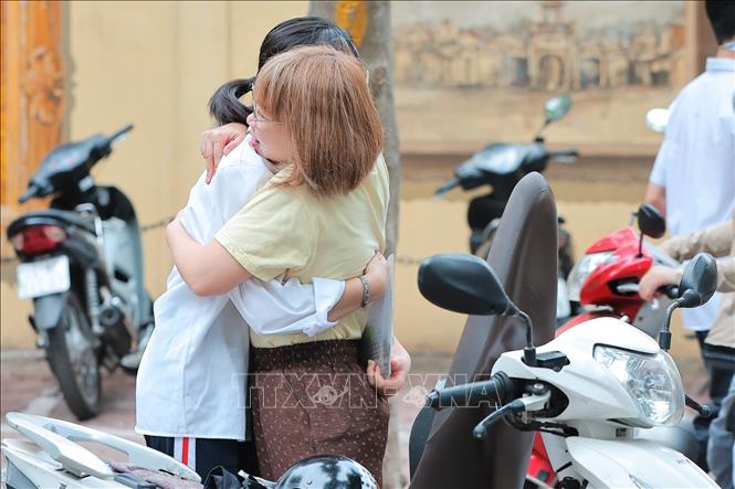 Phụ huynh ôm, động viên con em trước khi bước vào điểm thi Kỳ thi tốt nghiệp THPT năm 2026 tại điểm thi trường THPT Phan Đình Phùng. Ảnh: Lê Đông - TTXVN
