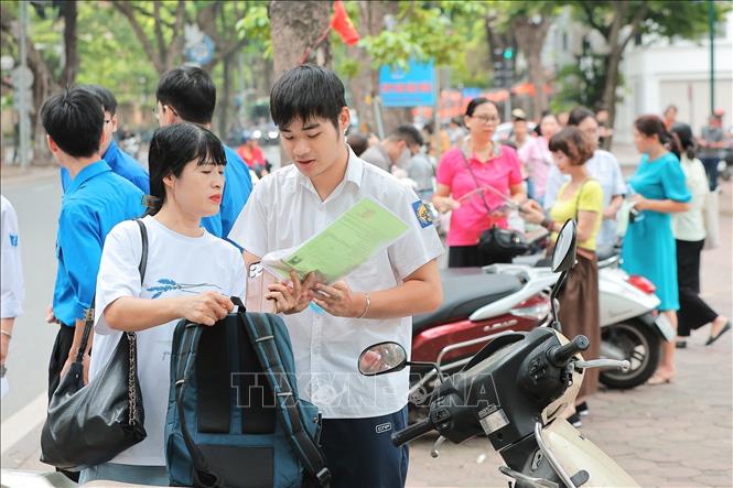 Phụ huynh cẩn thận kiểm tra lại giấy tờ, bút viết và các vật dụng cần thiết cho con trước khi bước vào điểm thi Kỳ thi tốt nghiệp THPT năm 2026 tại điểm thi trường THPT Phan Đình Phùng. Ảnh: Lê Đông - TTXVN
