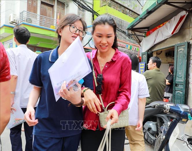 Phụ huynh chia sẻ cảm xúc với thí sinh sau khi hoàn thành môn thi đầu kỳ thi tốt nghiệp THPT năm 2026 tại điểm Trường THCS Ngô Quyền (phường Bạch Mai). Ảnh: Khánh Hoà - TTXVN