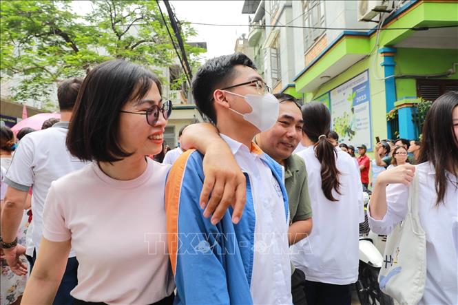 Phụ huynh chia sẻ cảm xúc với thí sinh sau khi hoàn thành môn thi đầu tiên tại điểm thi Trường THCS Ngô Quyền (phường Bạch Mai). Ảnh: Khánh Hoà - TTXVN