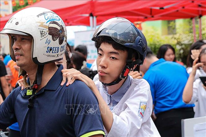 Rời điểm thi, Sơn đặt tay lên vai bố - một điểm tựa rất gần, rất quen, nơi em gửi trọn sự tin tưởng vào người đã làm “đôi chân” đồng hành cùng mình suốt 18 năm qua. Ảnh: Phạm Tuấn Anh - TTXVN