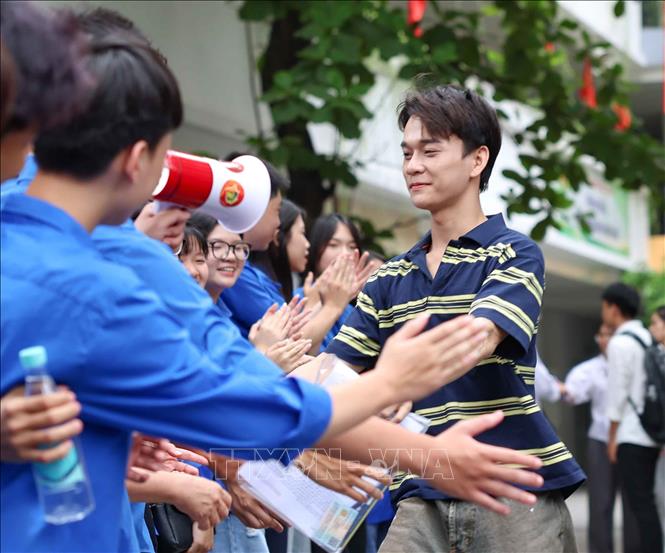 Thí sinh nhận tình cảm chân thành của lực lượng sinh viên tình nguyện sau khi hoàn thành môn thi đầu tiên tại điểm thi Trường THCS Ngô Sĩ Liên (phường Cửa Nam). Ảnh: Thanh Tùng - TTXVN 