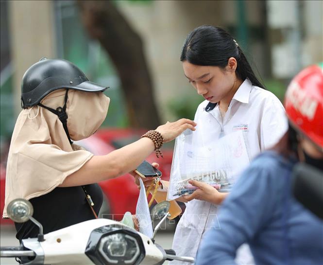Phụ huynh dặn dò thí sinh kiểm tra lại đồ dùng được phép mang vào phòng thi theo quy chế. Ảnh: Thanh Tùng - TTXVN
