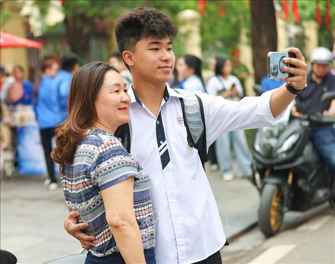 Rạng rỡ bên con trước khi con vào thi môn Toán. Ảnh: Thanh Tùng - TTXVN