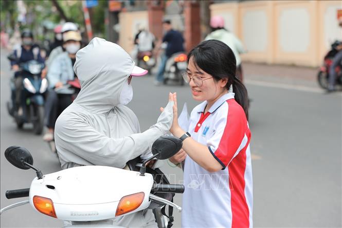 Phụ huynh tiếp thêm động lực và sự tự tin cho con trước giờ làm bài tại điểm thi Trường THCS Nguyễn Trãi (Hà Nội. Ảnh: Lê Đông - TTXVN