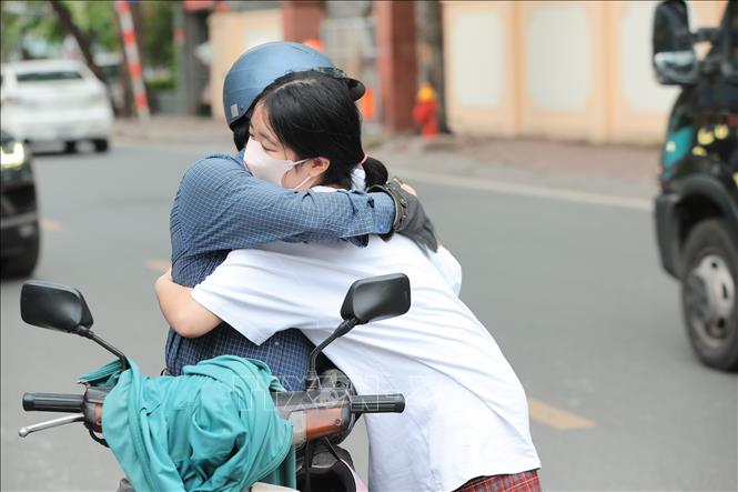Phụ huynh động viên con trước giờ làm bài, tiếp thêm động lực và sự tự tin cho thí sinh tại điểm thi Trường THCS Nguyễn Trãi (Hà Nội). Ảnh: Lê Đông - TTXVN