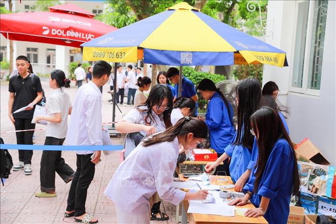 Thanh niên tình nguyện tại điểm thi trường THPT Đoàn Kết - Hai Bà Trưng (phường Bạch Mai) hỗ trợ thí sinh trước khi bước vào môn Toán. Ảnh: Khánh Hoà - TTXVN