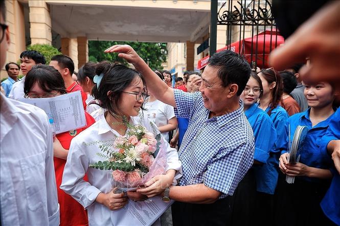 Ông ngoại chúc mừng cháu sau khi hoàn thành môn Toán. Ảnh: Phạm Tuấn Anh - TTXVN