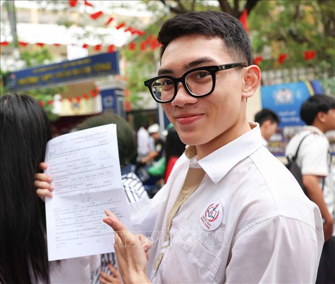 Thí sinh tại điểm thi Trường THPT Trần Nhân Tông tự tin khoe về bài thi môn Toán của mình. Ảnh: Thanh Tùng - TTXVN