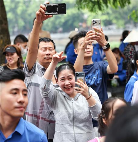 Phụ huynh hồi hộp chờ đón thí sinh bên ngoài điểm thi Trường THPT Trần Nhân Tông. Ảnh: Thanh Tùng - TTXVN