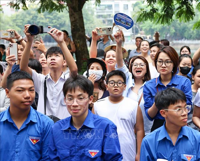 Phụ huynh hồi hộp chờ đón thí sinh bên ngoài điểm thi Trường THPT Trần Nhân Tông. Ảnh: Thanh Tùng - TTXVN